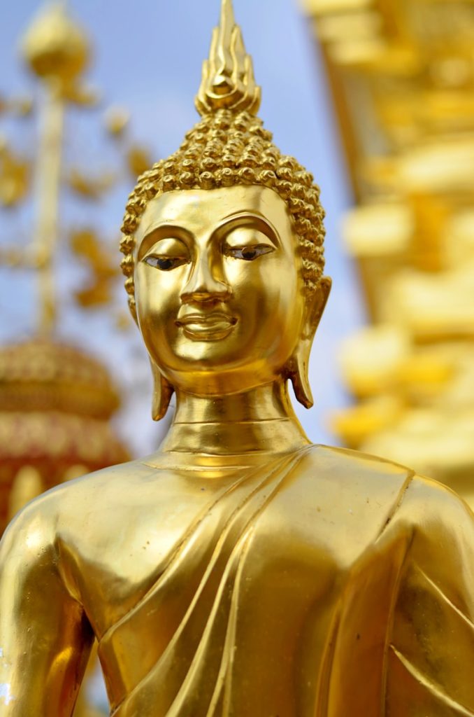 Photo by Laurentiu Morariu gold buddha statue during daytime