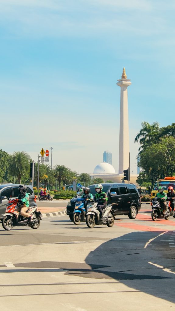 Photo by Fairuz Naufal Zaki a group of people riding motorcycles down a street