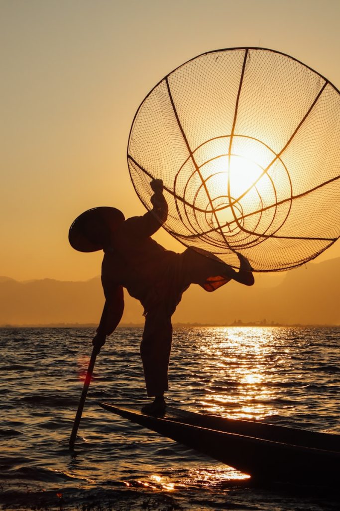 Photo by Thien Kim Nguyen Trinh silhouette of man holding basketball during sunset