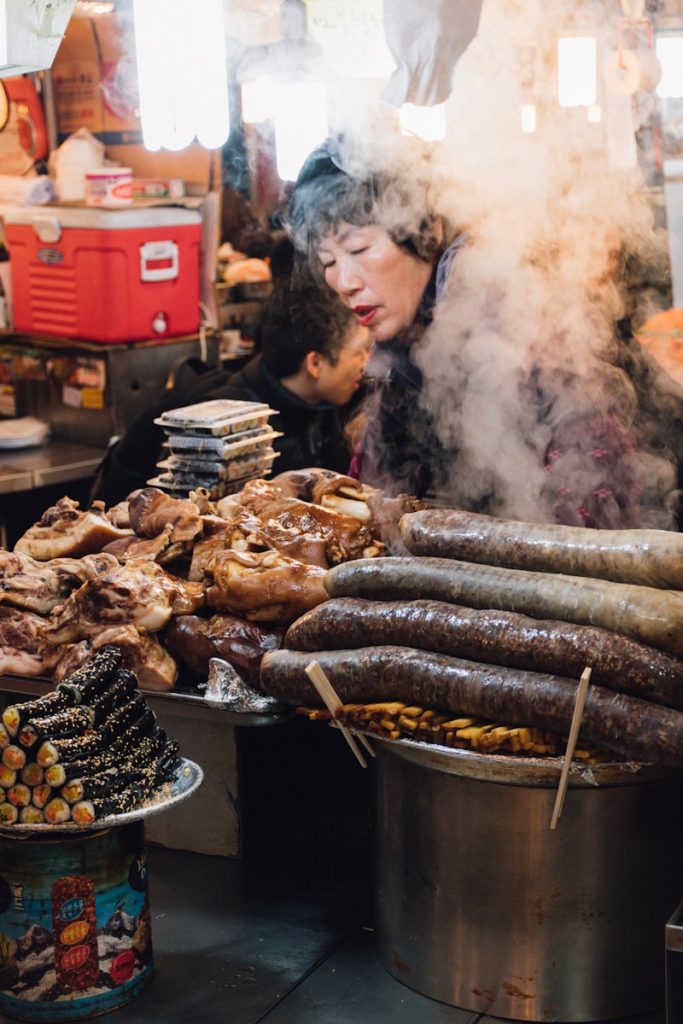 Photo by CJ Dayrit woman standing in front of assorted grilled food