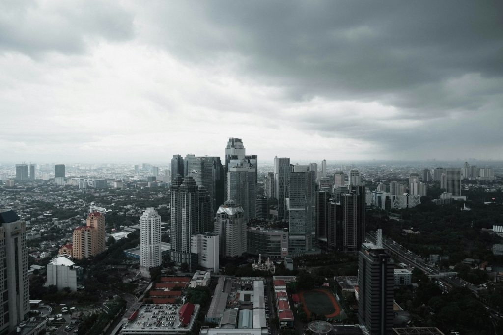 Photo by David Kristianto an aerial view of a city with tall buildings