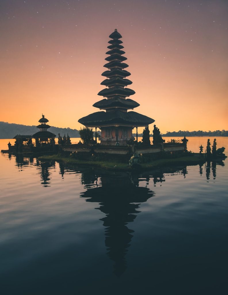 Photo by Aron Visuals temple in between body of water